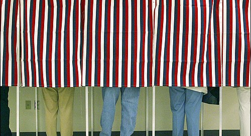 A photograph of occupied voting booths with curtains drawn 