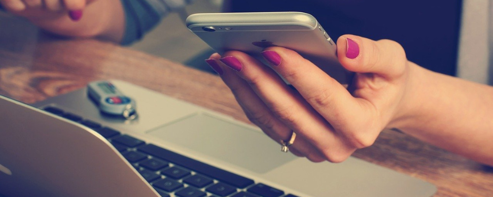 break up with bad ux design woman holding mobile phone in front of laptop