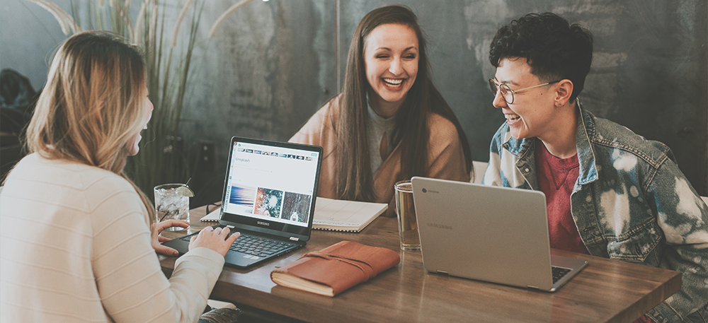 Users laughing near laptops